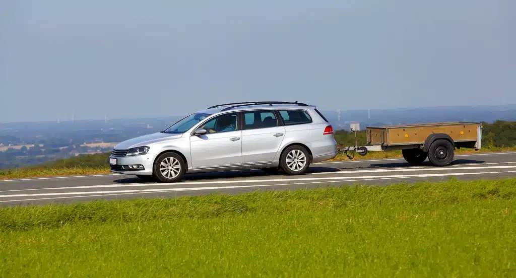 Auto mit Anhänger fährt auf einer Landstraße