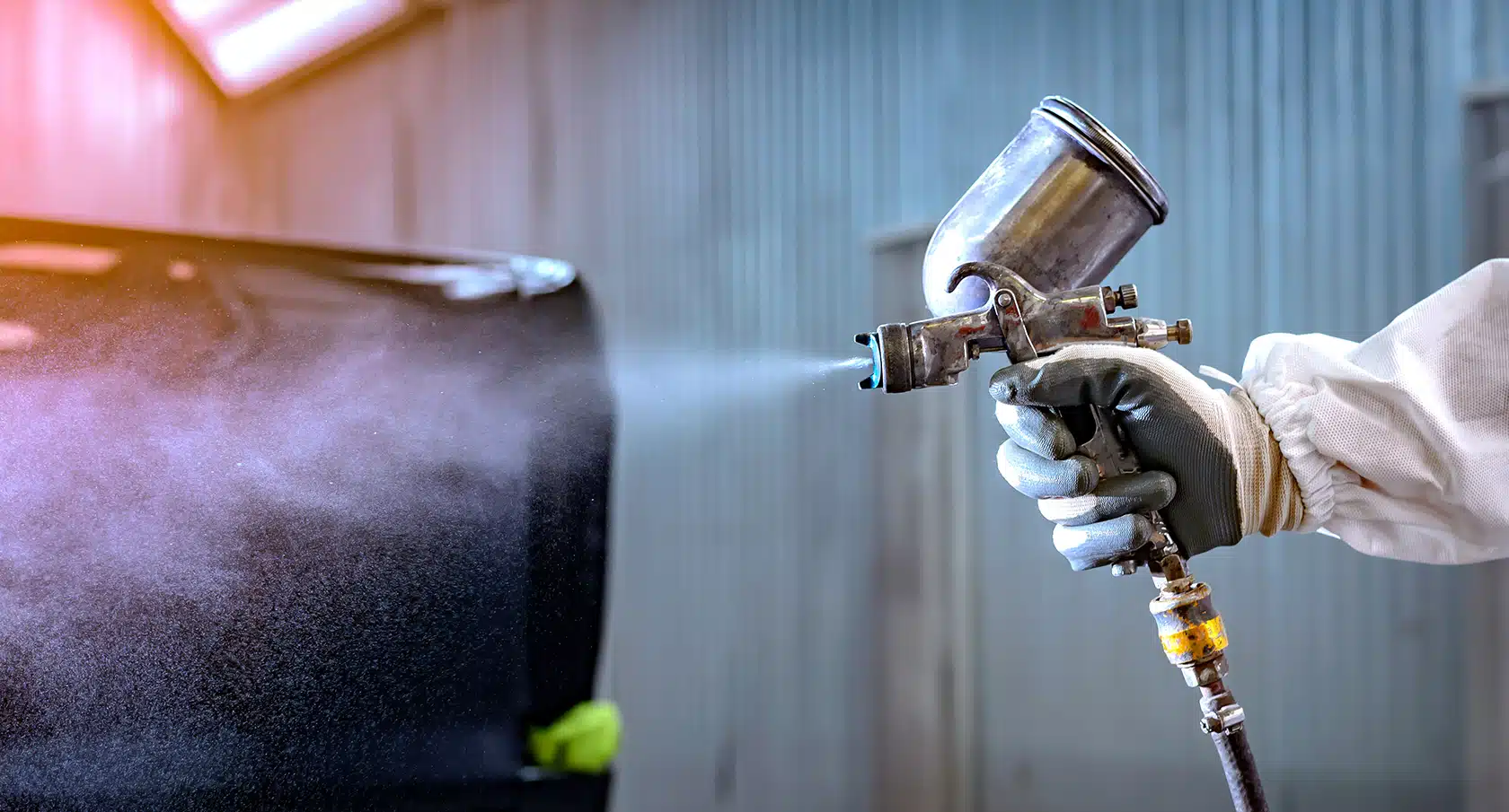 Eine Hand bedient eine Auto-Lackiermaschine