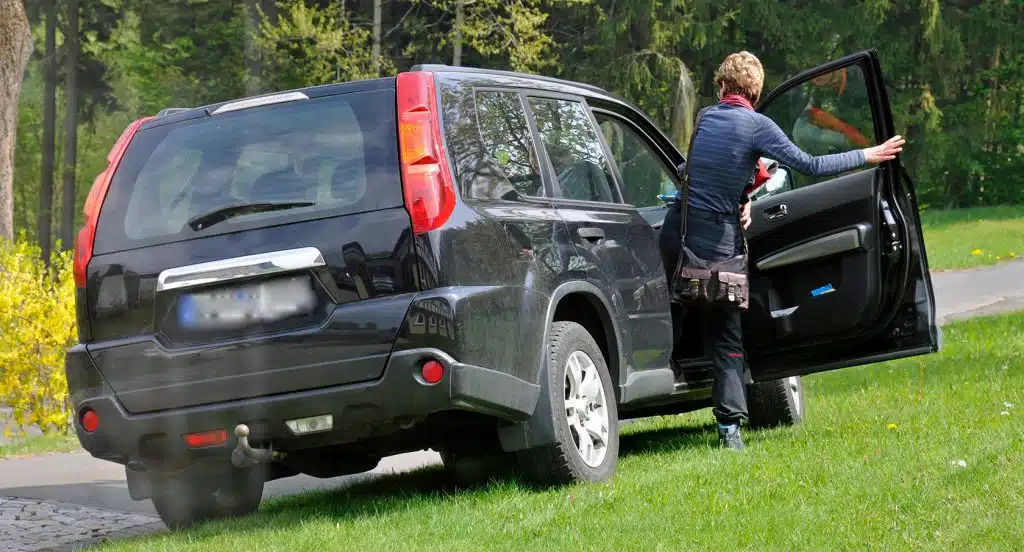 Beifahrer steigt aus einem parkenden Auto aus