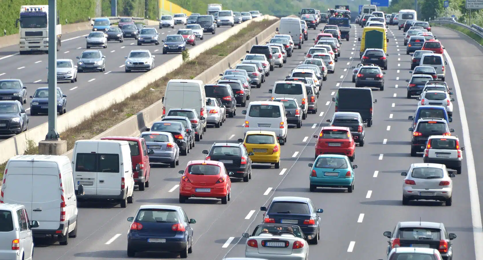 Foto einer voll befahrenen dreispurigen Autobahn.