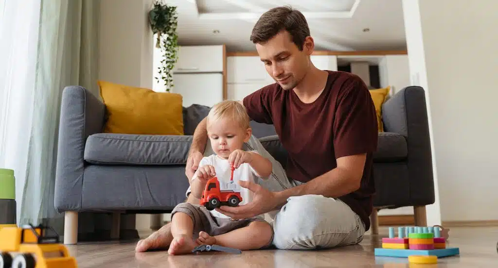 Vater und kleines Kind spielen mit einem Spielzeugauto