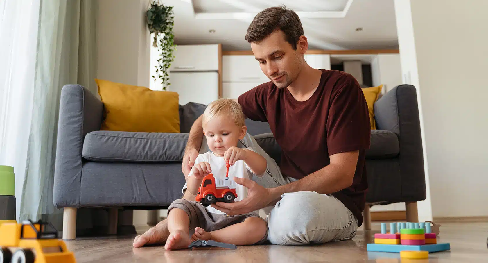 Vater und kleines Kind spielen mit einem Spielzeugauto