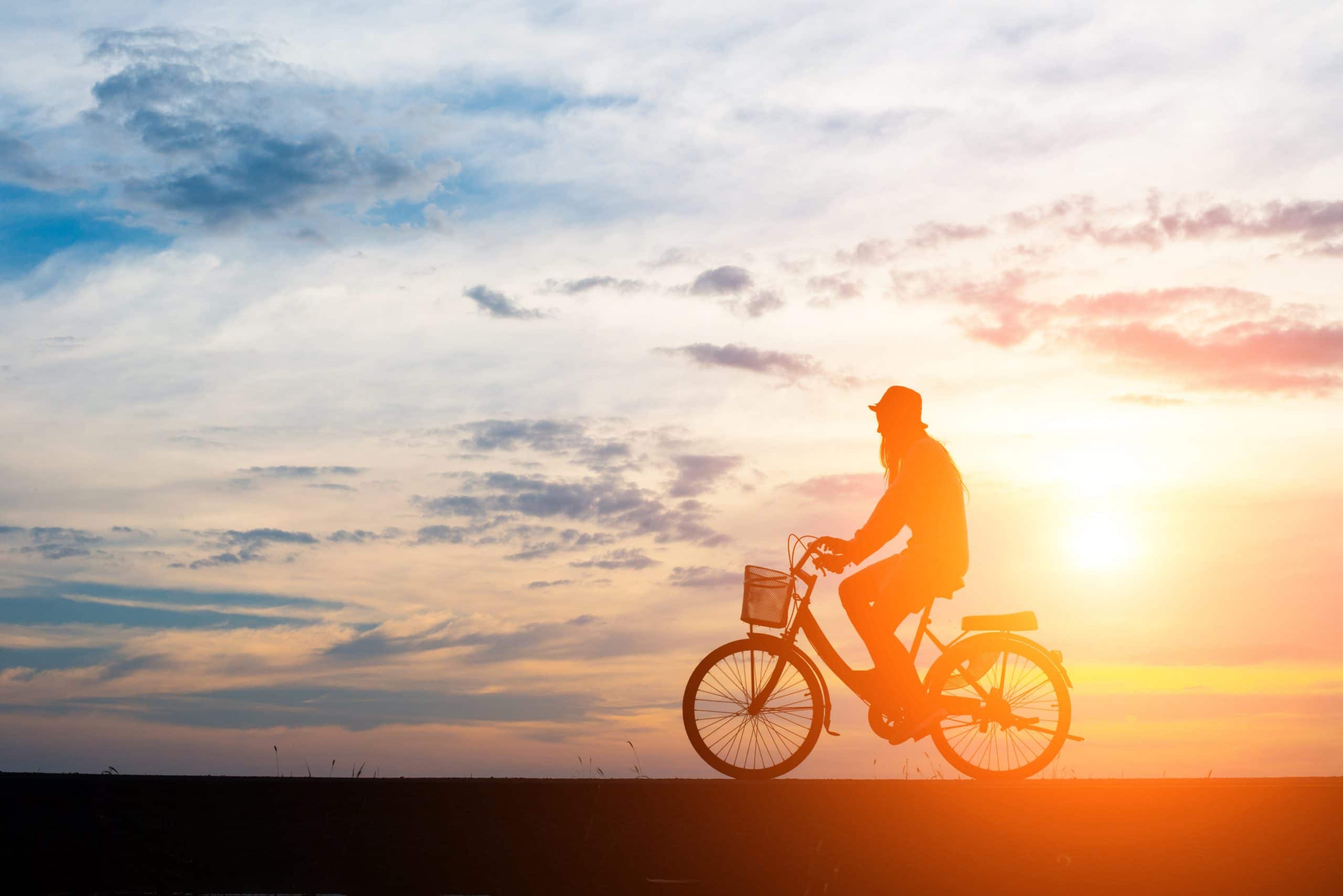 Young man ride bicycle on sunset background. Fahrlassigkeit Vorsatz