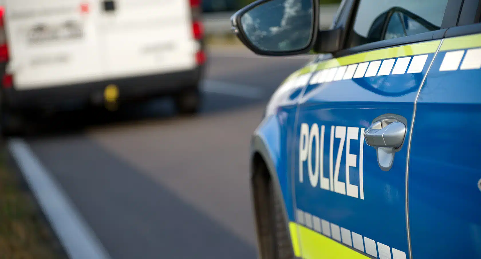 Polizeiauto fährt hinter einem Lieferwagen her