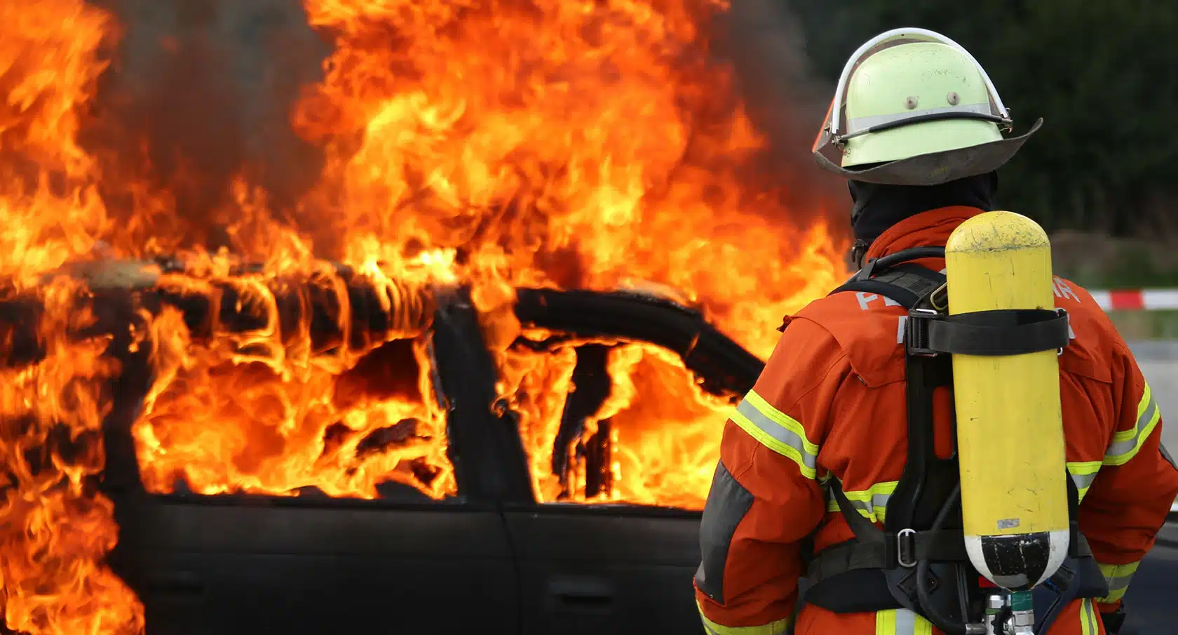 Feuerwehrmann löscht einen Fahrzeugbrand