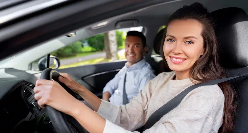 Fahrlehrer und Schülerin sitzen in einem Fahrschulauto