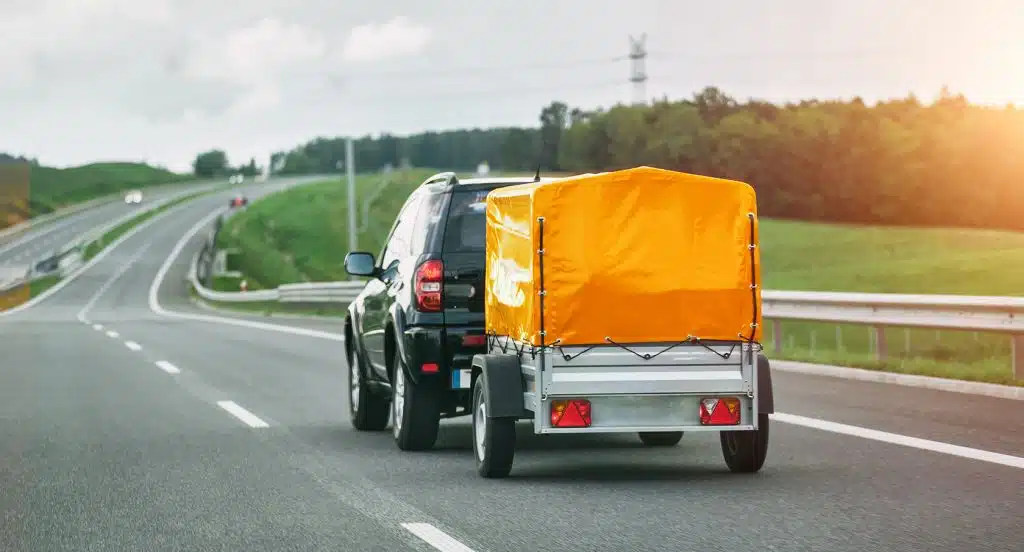 Auto mit Anhänger fährt auf einer Straße