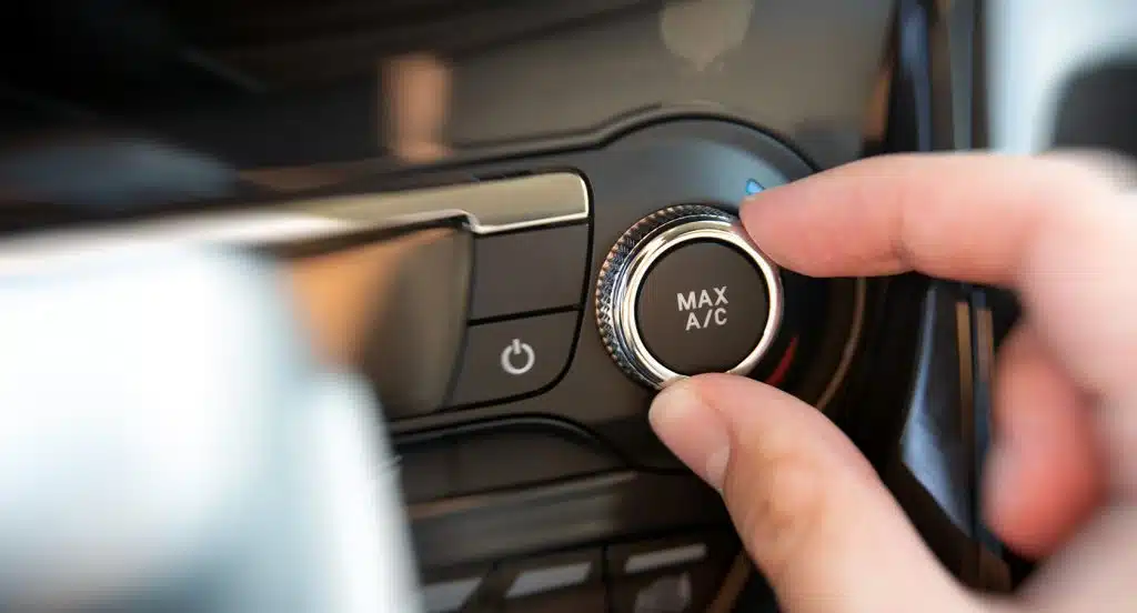 Eine Hand stellt den Regler der Autoheizung ein
