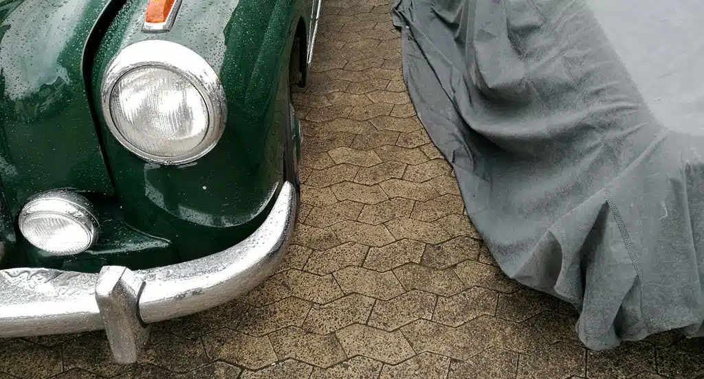 Mit einer Plane abgedeckter Oldtimer