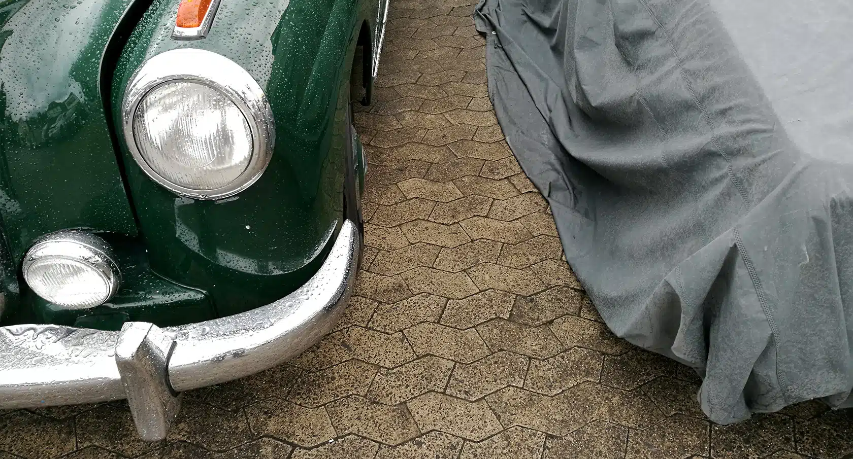 Mit einer Plane abgedeckter Oldtimer