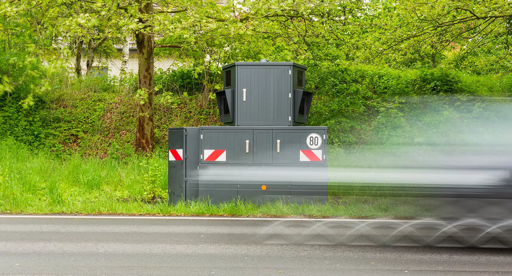 Versteckte Radarfalle vor einem Gebüsch