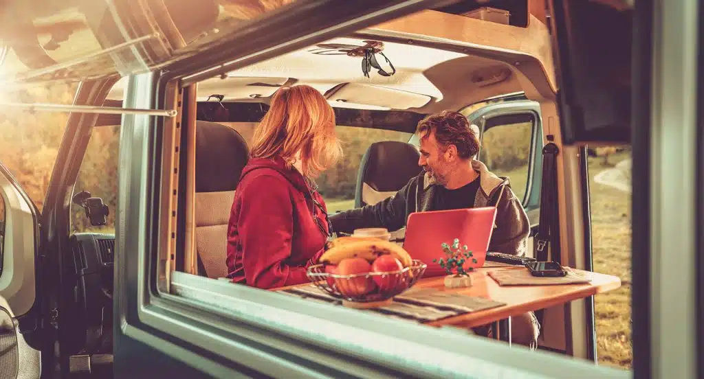 Ein Pärchen sitzt in einem Wohnmobil am Tisch