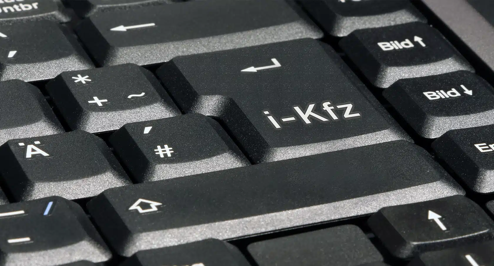 Eine Computertastatur mit dem Schriftzug "i-Kfz" auf der Entertaste