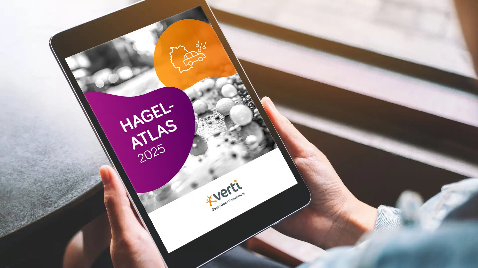 Zwei Hände halten ein Tablet, auf dem der Hagel-Atlas 2025 angezeigt wird