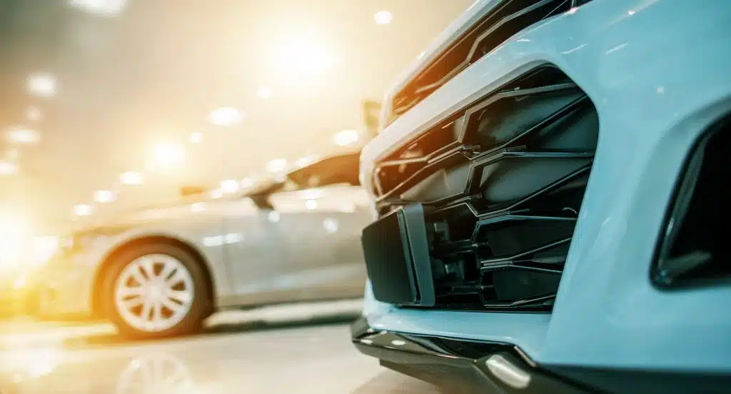 Die Front eines Autos in Großaufnahme steht vor einem teilweise verdeckten anderen modernen Auto