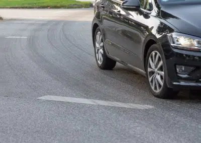 Auto in Kurve mit Reifenabrieb