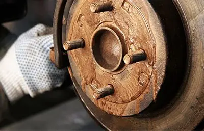 Neue Bremsbeläge liegen auf der Bremsscheibe eines Autorads