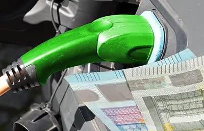 E-Auto beim Laden mit Geldschein im Vordergrund