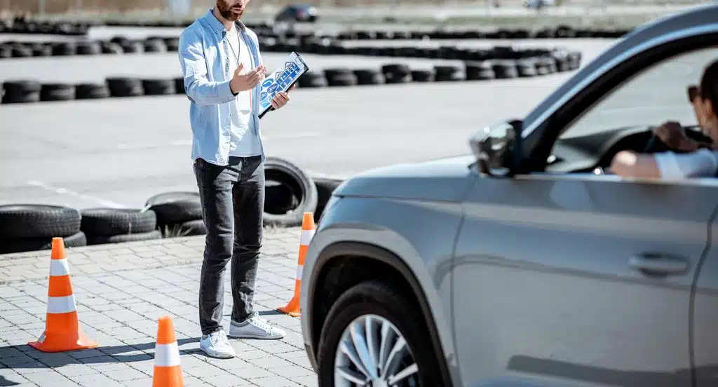 Prüfer und Fahrzeug bei einem Fahrsicherheitstraining