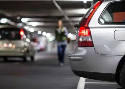 Frau läuft durch ein Parkhaus zu ihrem Auto