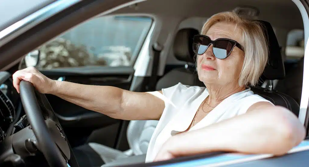 Eine Autofahrerin lehnt während der Fahrt lässig ihren Arm aus dem Fenster eines Autos