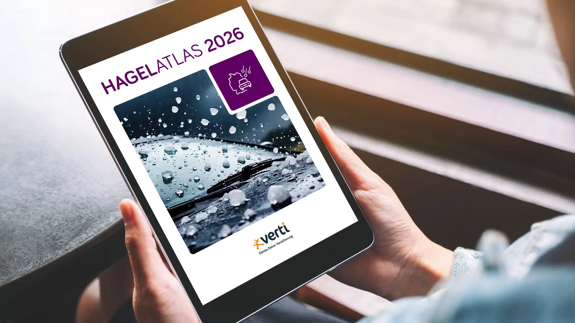 hagelatlas-mockup-tablet Zwei Hände halten ein Tablet, auf dem der Hagel-Atlas 2025 angezeigt wird