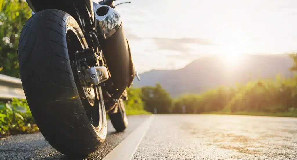 Hinterrad eines Motorrads in Großaufnahme auf einer Landstraße
