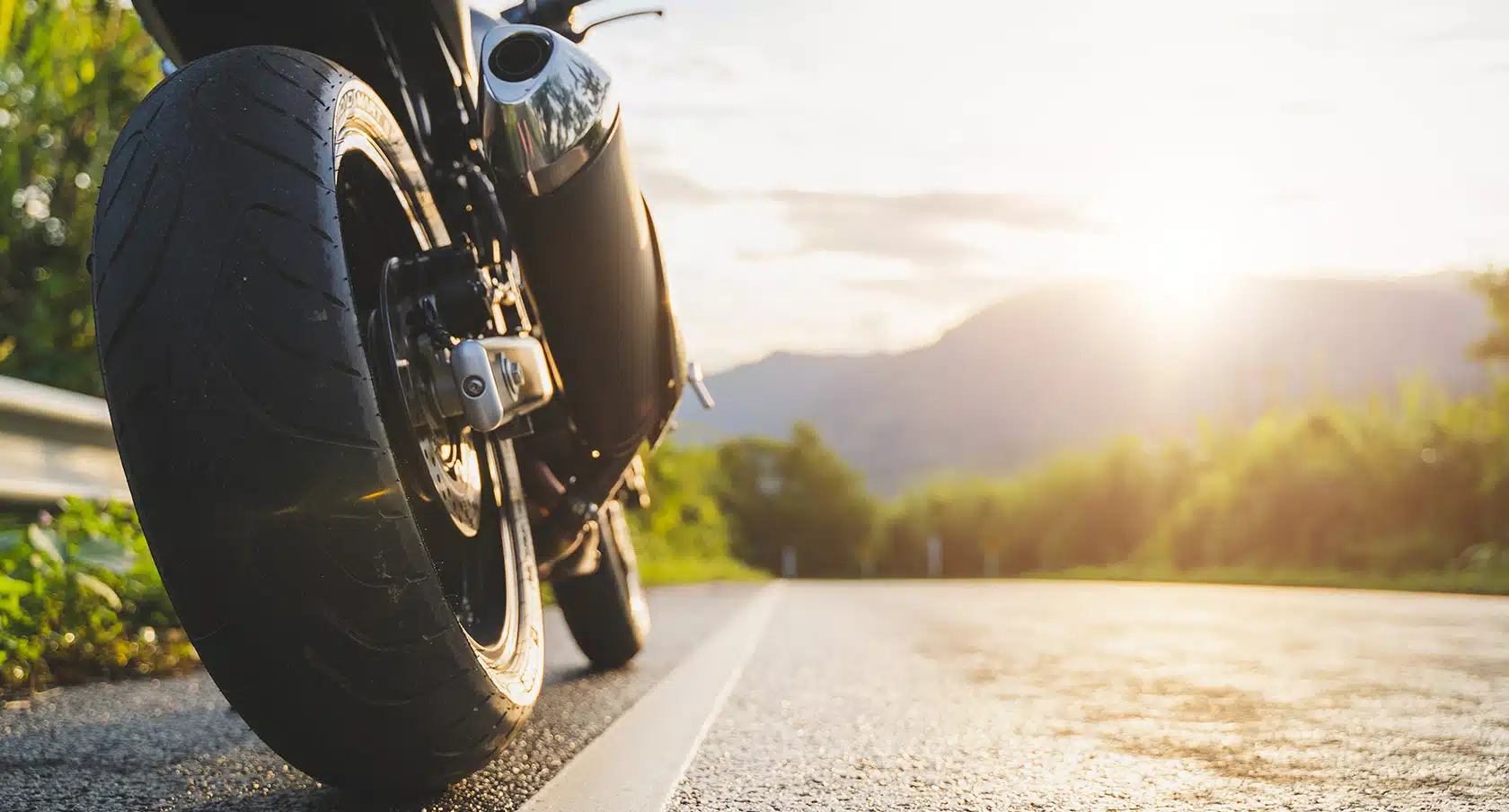 Hinterrad eines Motorrads in Großaufnahme auf einer Landstraße