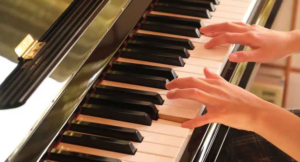 Zwei Hände spielen auf einem Piano