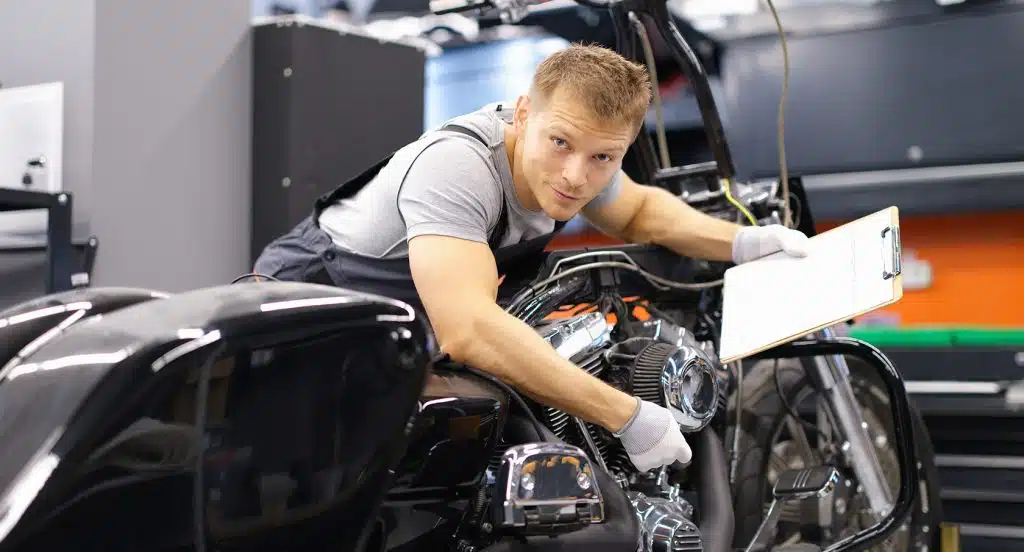 Mechaniker mit einer Liste in der Hand prüft ein Motorrad