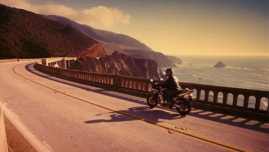 Motorradfahrer fährt an der Küste entlang