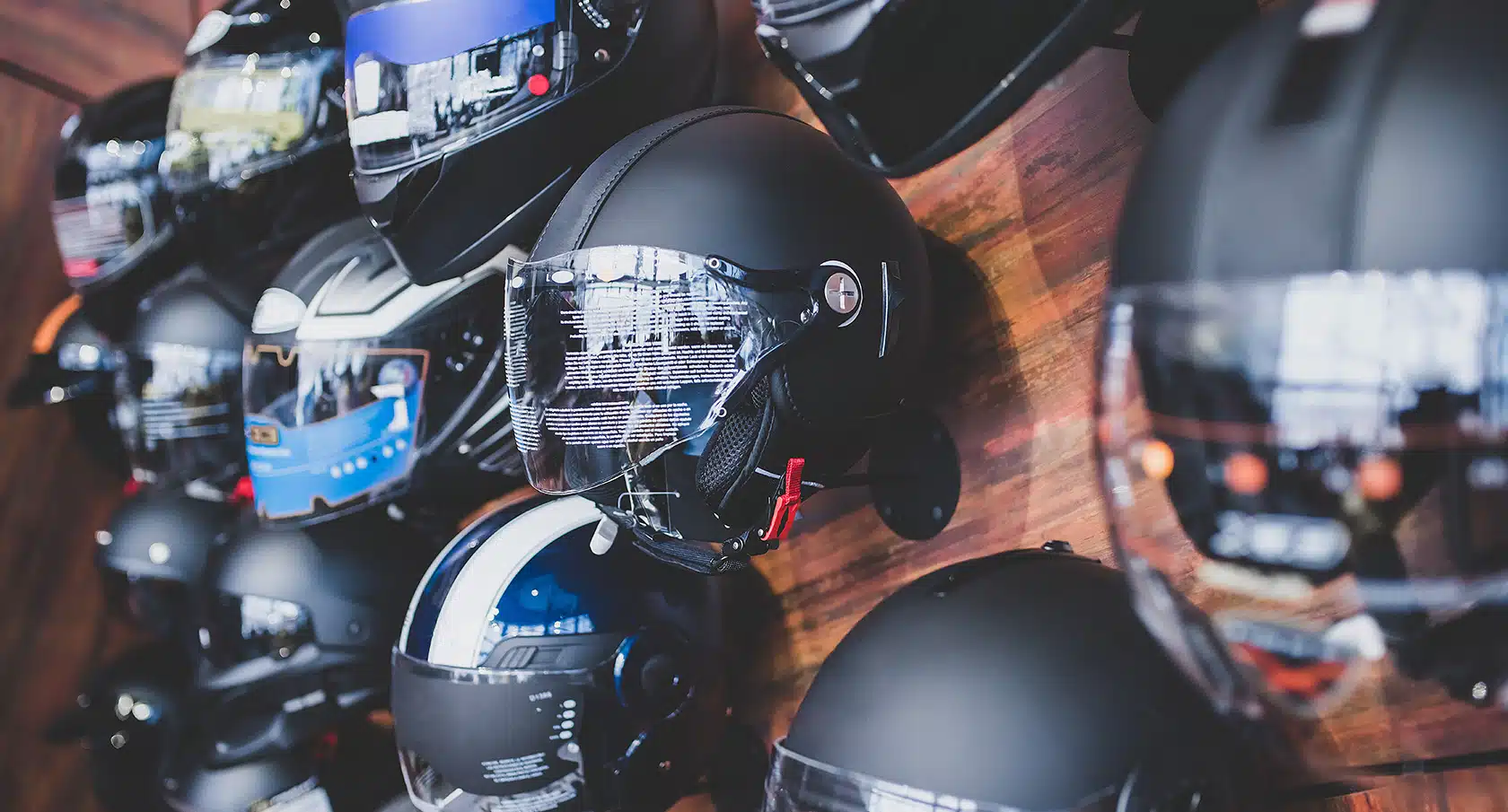 Mehrere Motorradhelme hängen an der Wand nebeneinander