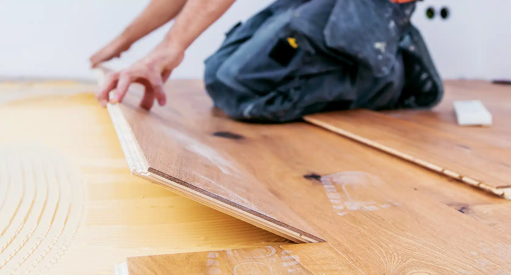 Handwerker beim Verlegen eines Parkettbodens