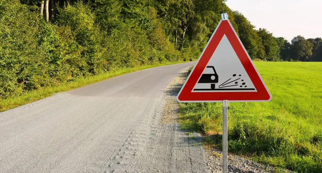 Straßenschild "Rollsplit" an einer Straße im Grünen