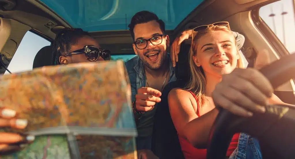 Insassen eines Autos fahren mit einer Karte in den Urlaub