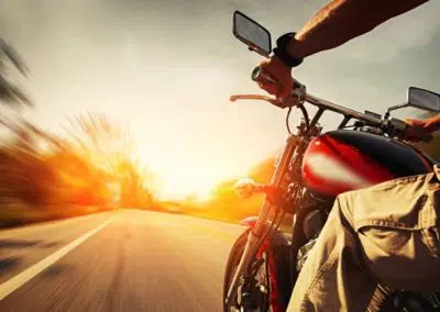 Motorradfahrer fährt in den Sonnenuntergang