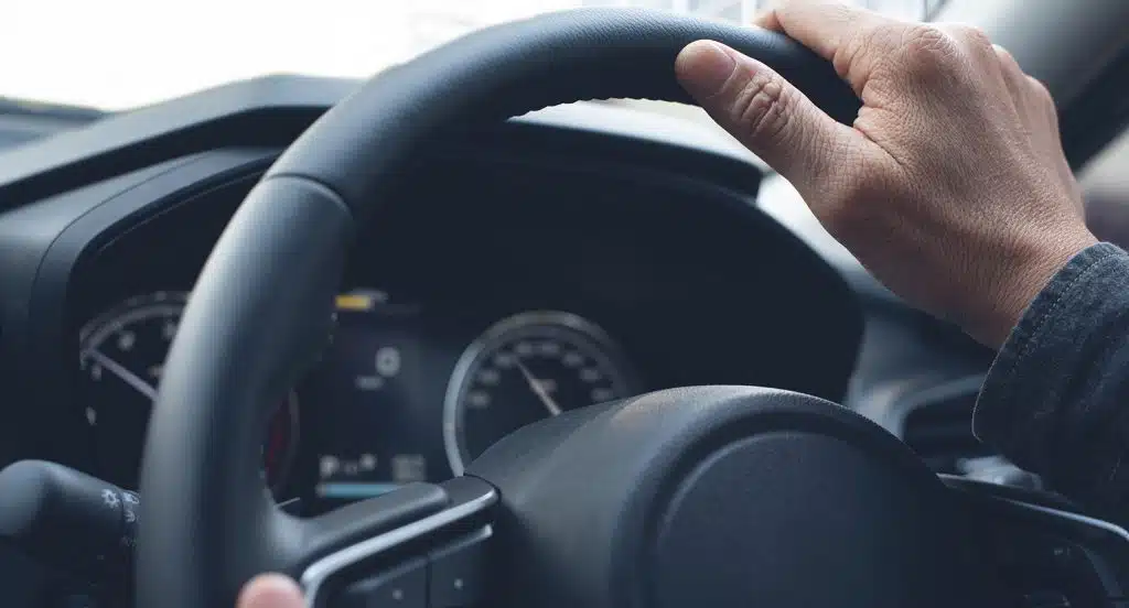 Hand an einem Lenkrad eines Autos