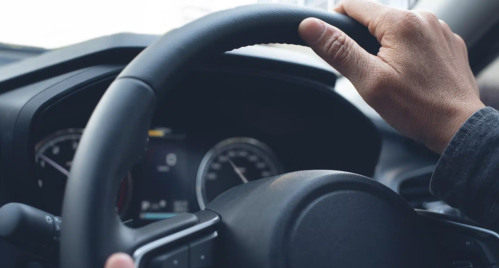 Hand an einem Lenkrad eines Autos